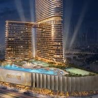 Illuminated high-rise building with curved architecture, labeled "Danube Properties," featuring a pool and garden area, set against a cityscape at night.