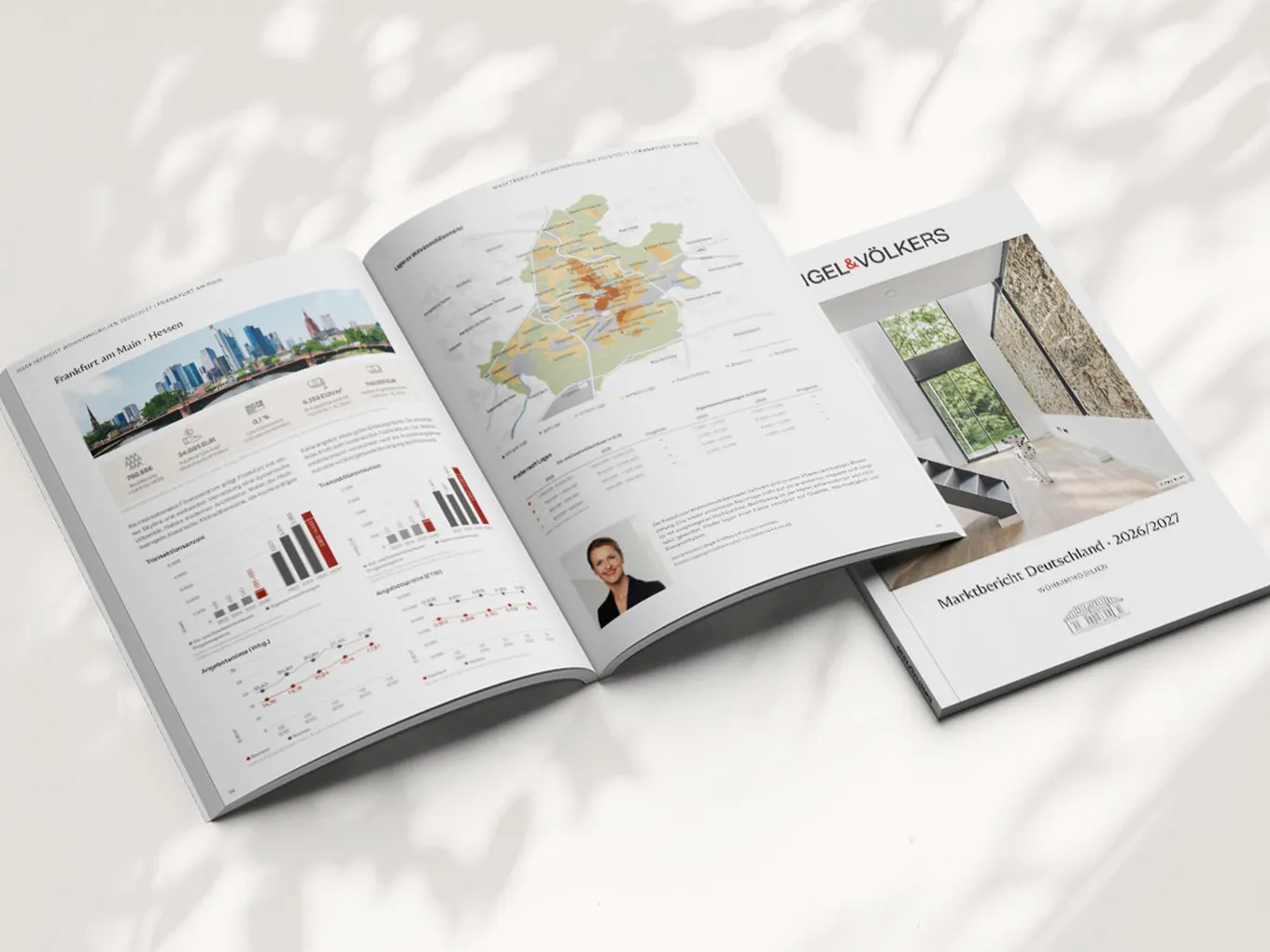 Open real estate brochure spread: city skyline with charts, a colorful map, and a separate Engel & Völkers interior cover.