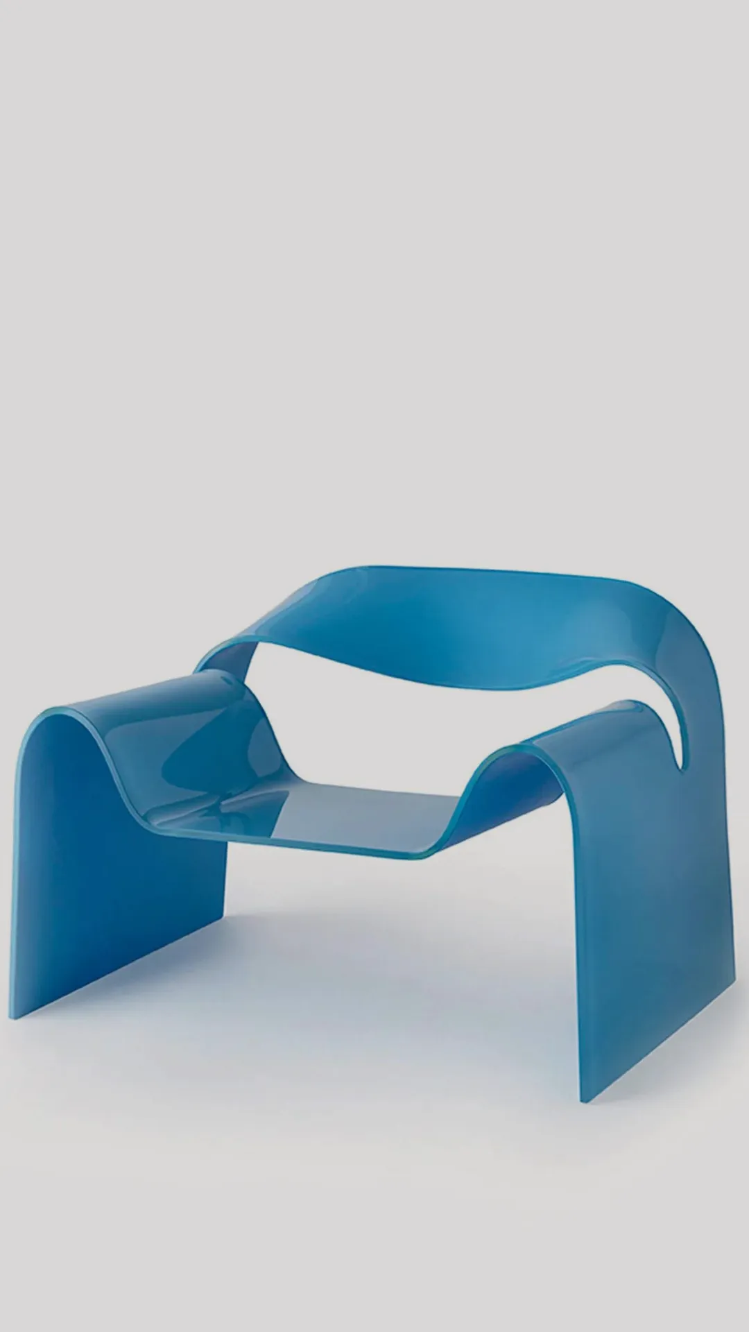 Blue sculptural plastic chair with curved loop sides and integrated seat, set against a light gray backdrop.
