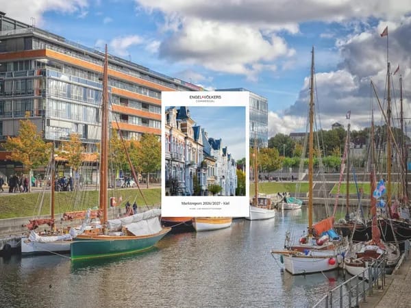 A harbor canal with anchored sailboats, modern glass buildings, and autumn trees; in the center is a white-framed poster featuring a row of houses.