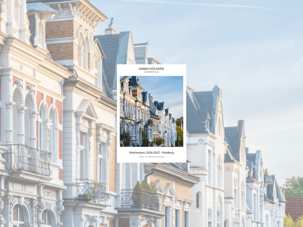 Sunlit row of ornate pastel townhouses with gables and balconies; a white Engel & Völkers Commercial brochure centered on the image.