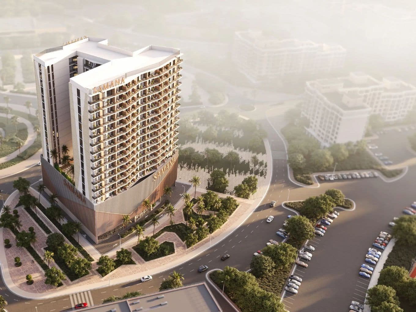 Aerial view of a high-rise building with curved balconies, surrounded by trees and roads, in a foggy urban setting.