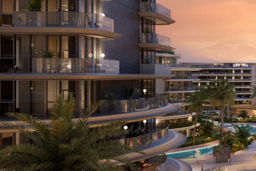 Modern luxury apartments with curved balconies overlook a pool and lush greenery at sunset.