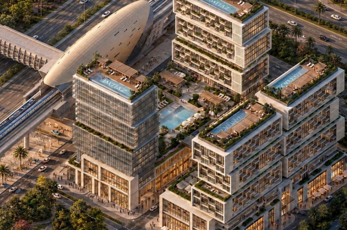 Modern architectural complex with rooftop pools, glass facades, and an adjoining transit station, surrounded by palm trees and roads.
