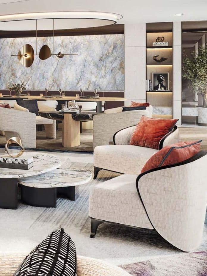 Modern living room with a stylish seating area, marble tables, colorful pillows, and elegant lighting. A large mural and potted tree enhance the decor.