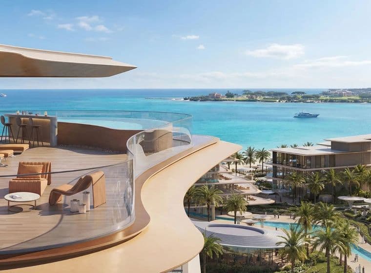 A luxurious beachfront resort with curved balcony, elegant furniture, palm trees, and a boat on turquoise water under a clear blue sky.