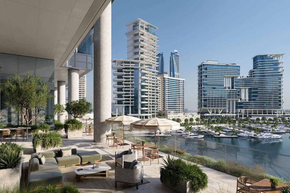 Spacious terrace with seating, overlooking a modern marina and high-rise buildings under a clear blue sky.