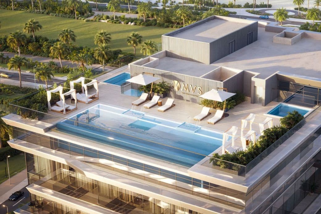 Rooftop infinity pool with lounge chairs, cabanas, and greenery, overlooking a lush landscape and palm trees.