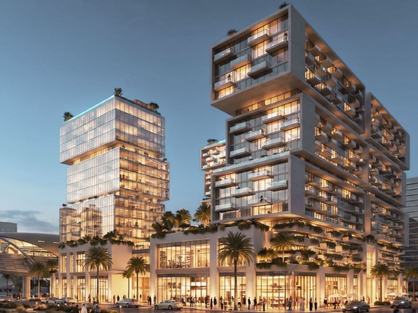 Modern, illuminated building complex with stacked glass structures, surrounded by palm trees at dusk, with people and cars in the foreground.