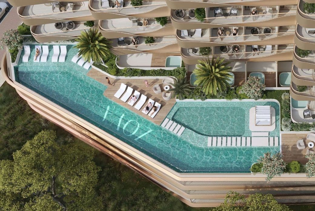 Aerial view of a luxurious building with a rooftop pool, sun loungers, and lush greenery, surrounded by curved balconies with outdoor seating.