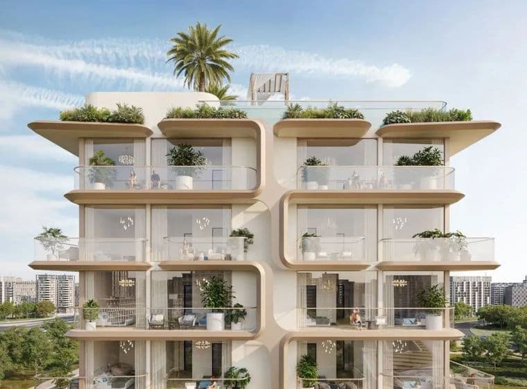 Modern multi-story building with curved balconies, glass railings, and rooftop greenery. Cityscape visible in the background under a blue sky.
