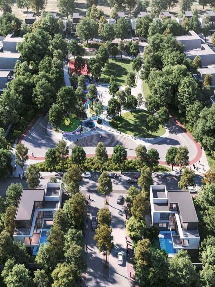 Aerial view of a suburban neighborhood with houses, a central park featuring a winding path, colorful playground, and lush trees.