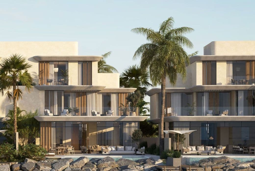 Full-frontal view of Anantara villas with palm trees, large balconies, and private dock access.