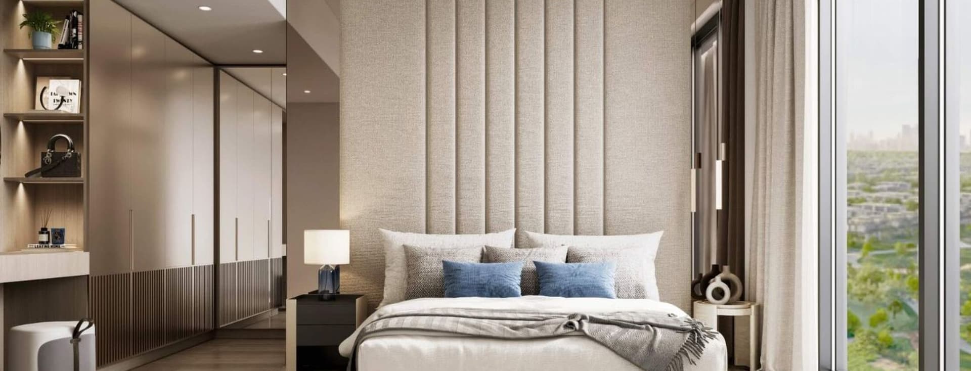Modern bedroom with large window, beige tones, upholstered headboard, double bed, blue cushions, and contemporary hanging light fixture.