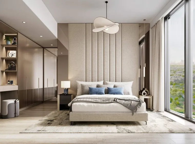 Modern bedroom with large window, beige tones, upholstered headboard, double bed, blue cushions, and contemporary hanging light fixture.