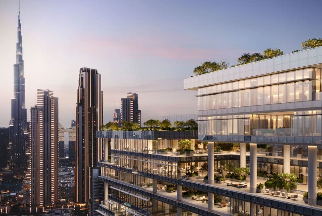 Modern high-rise building with greenery on terraces, set against a city skyline featuring the Burj Khalifa at sunset.