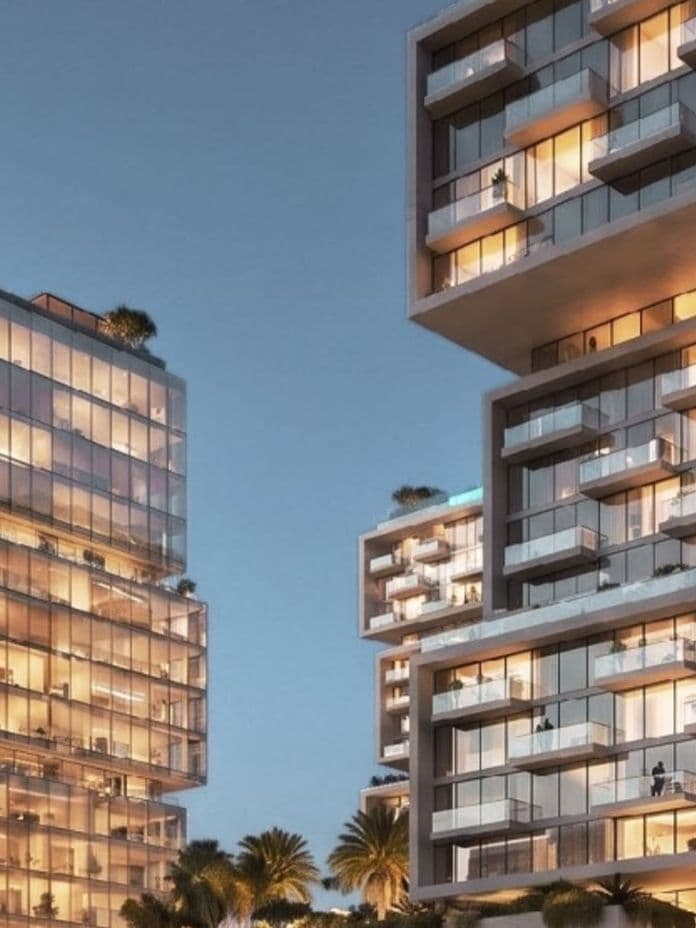 Modern high-rise buildings with illuminated glass facades and balconies at dusk, surrounded by palm trees.