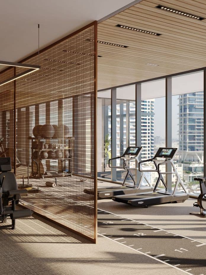 Modern gym with large windows, treadmills, exercise machines, and mirrored walls. Wooden accents provide a warm and inviting atmosphere.