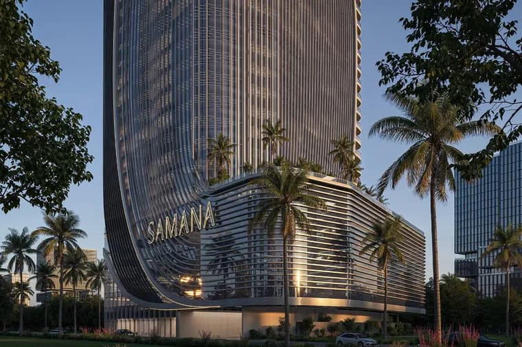A futuristic glass high-rise with a curved, wave-like façade and a SAMANA sign on its base, surrounded by palm trees and tropical landscaping.