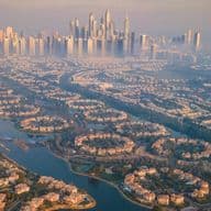 Aerial view of a misty morning in Dubai with Jumeirah Islands and Dubai Marina skyline