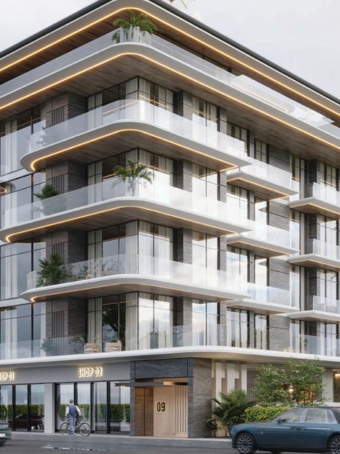 Modern multi-story building with glass balconies, lush plants, and sleek design. Ground level has shop entrances and parked cars in front.