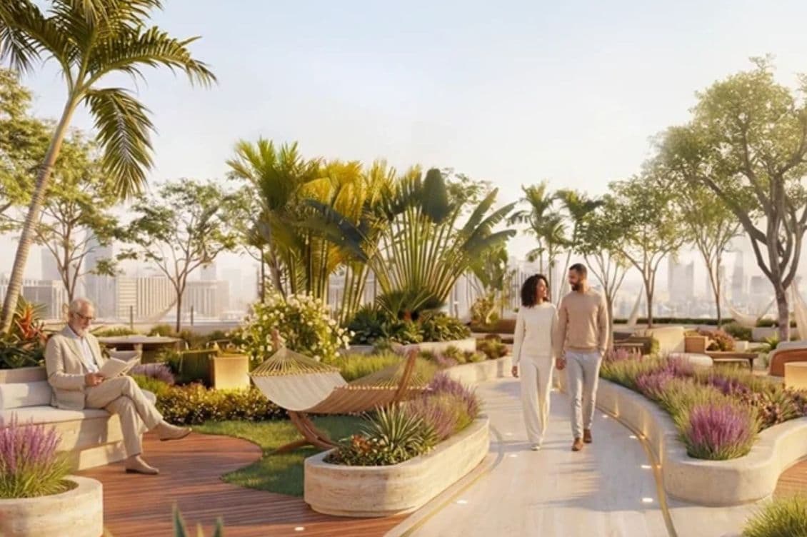 Rooftop garden with trees, plants, a hammock, and a seating area. A couple walks along a path, while a person reads on a bench with a city view.