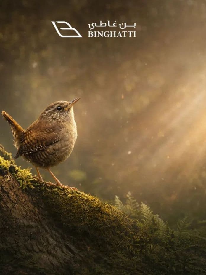 A small bird perches on a mossy tree trunk in a forest, with sunlight streaming through the trees. Binghatti logo is at the top.
