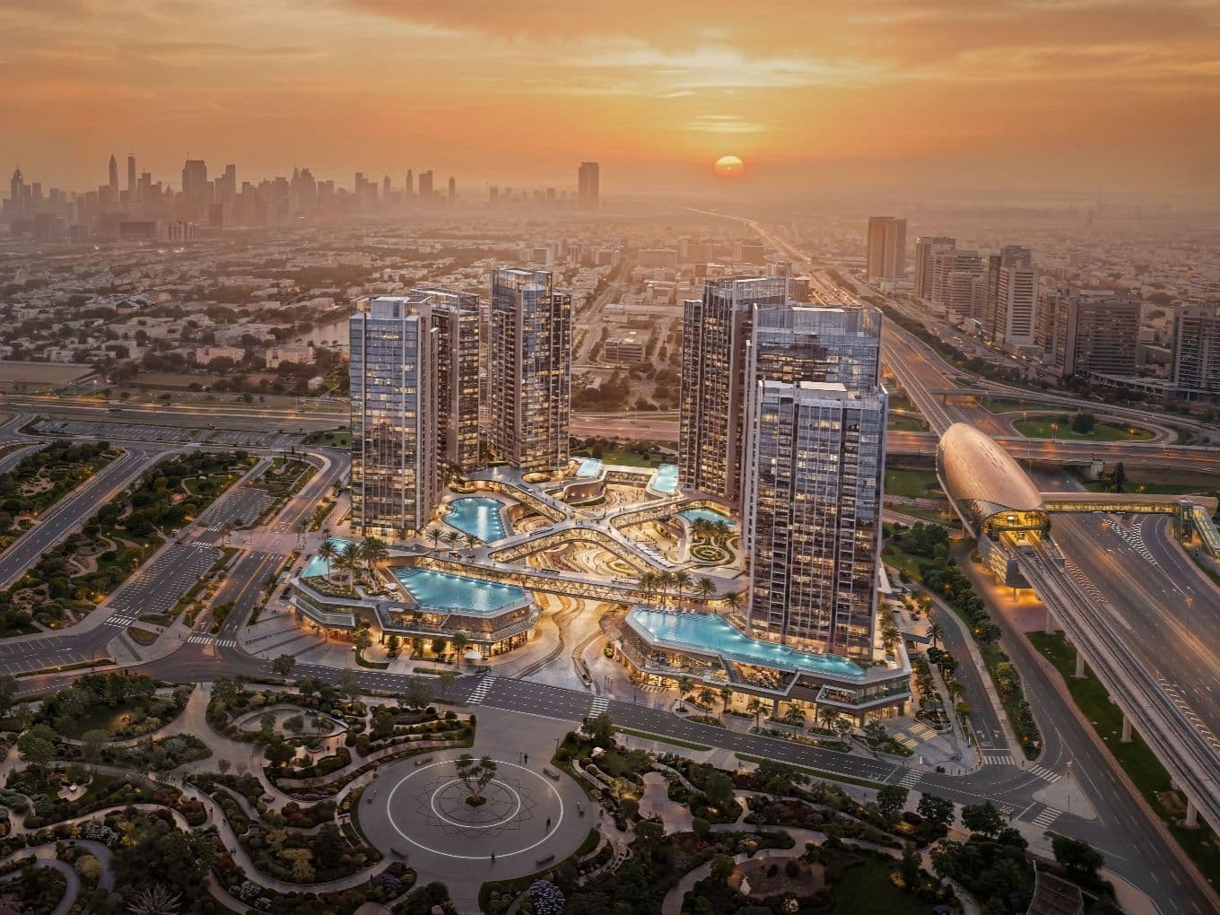 Aerial view of a cityscape at sunset, featuring modern skyscrapers, illuminated pools, and intricate road networks in the foreground.