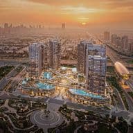 Aerial view of a cityscape at sunset, featuring modern skyscrapers, illuminated pools, and intricate road networks in the foreground.