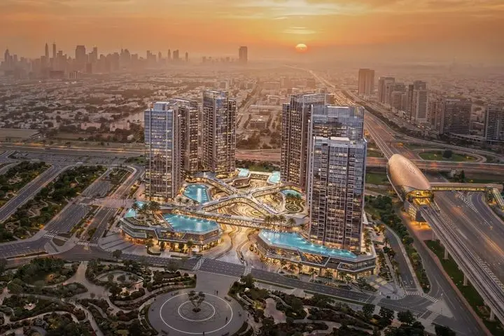 Aerial view of a cityscape at sunset, featuring modern skyscrapers, illuminated pools, and intricate road networks in the foreground.