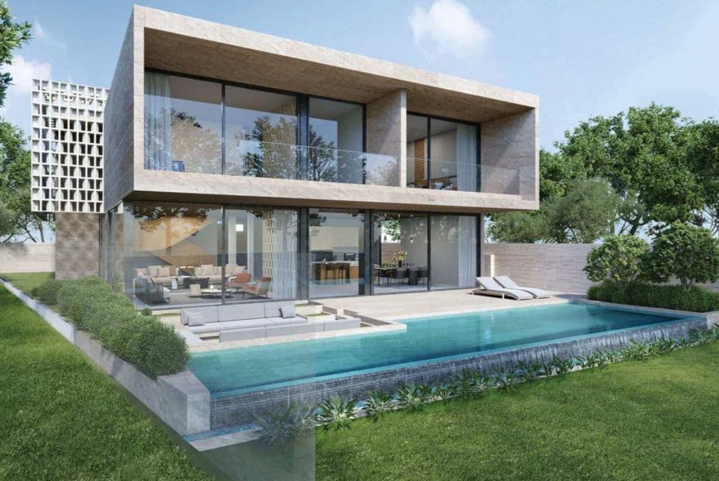 Modern two-story house with large glass windows, spacious patio, infinity pool, and surrounding greenery under a clear blue sky.