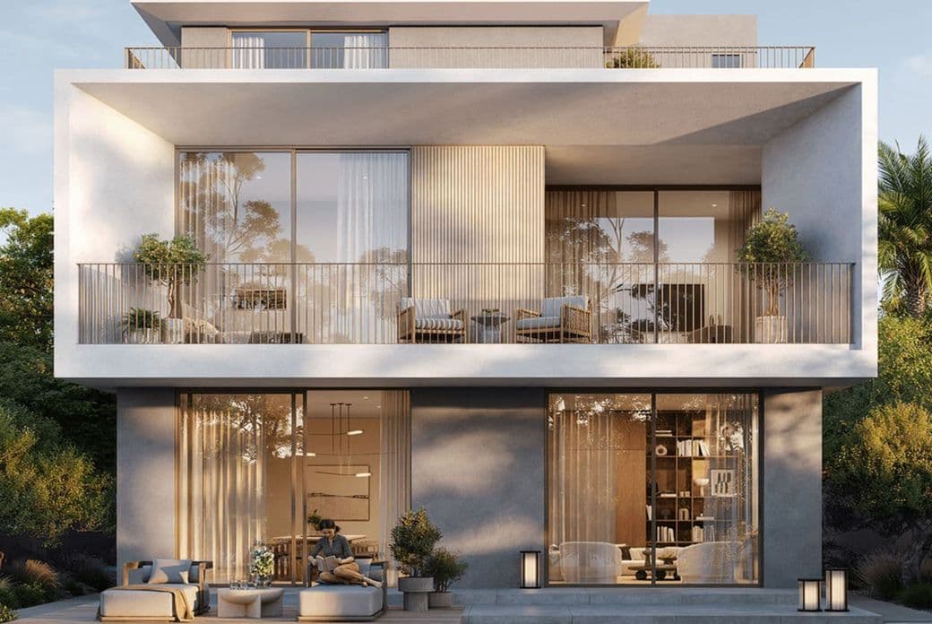 Modern multi-story house with large glass windows, balconies, outdoor seating, and a pool. Surrounded by greenery under a clear sky.