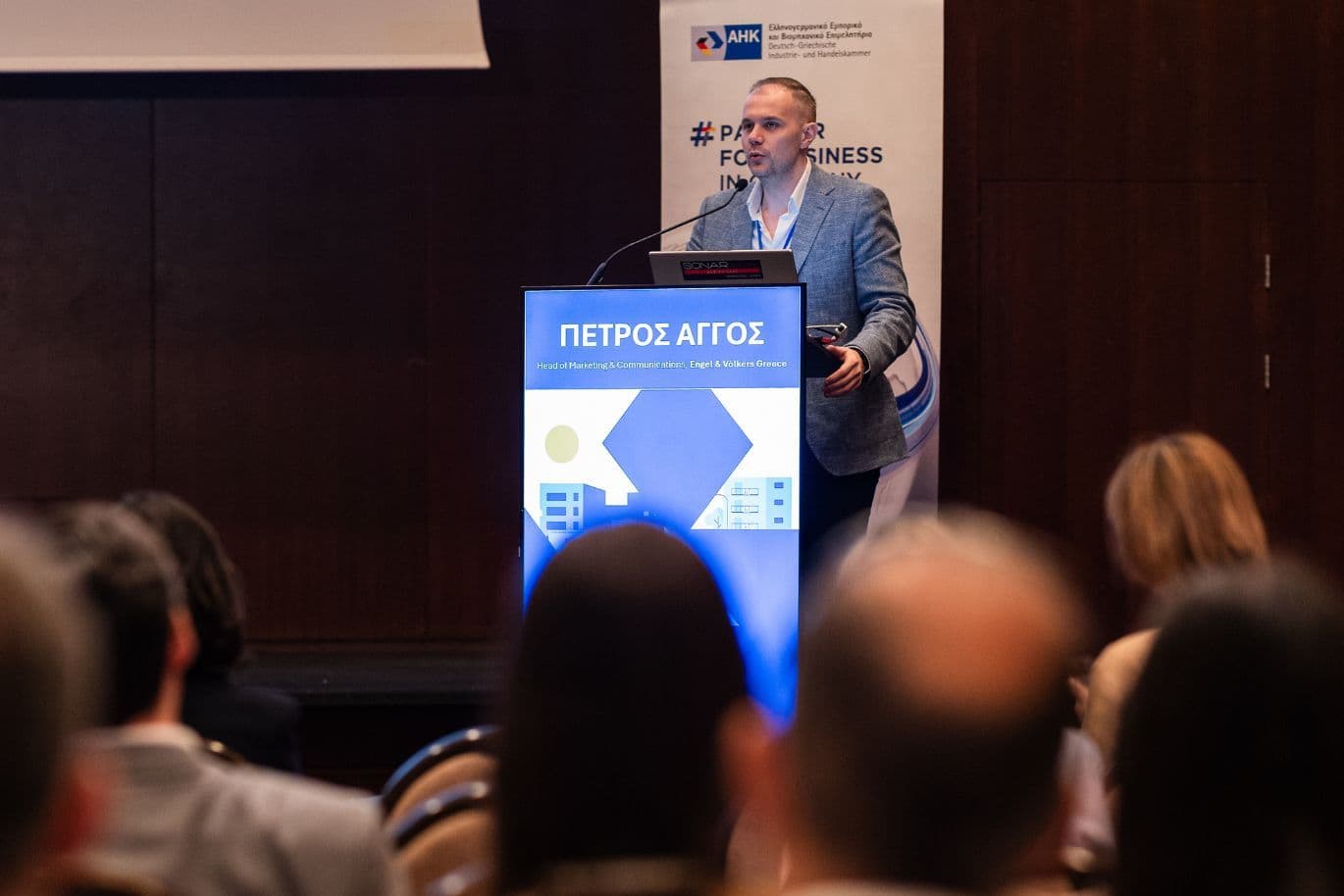 Speaker delivering a presentation at a real estate forum attended by industry professionals.