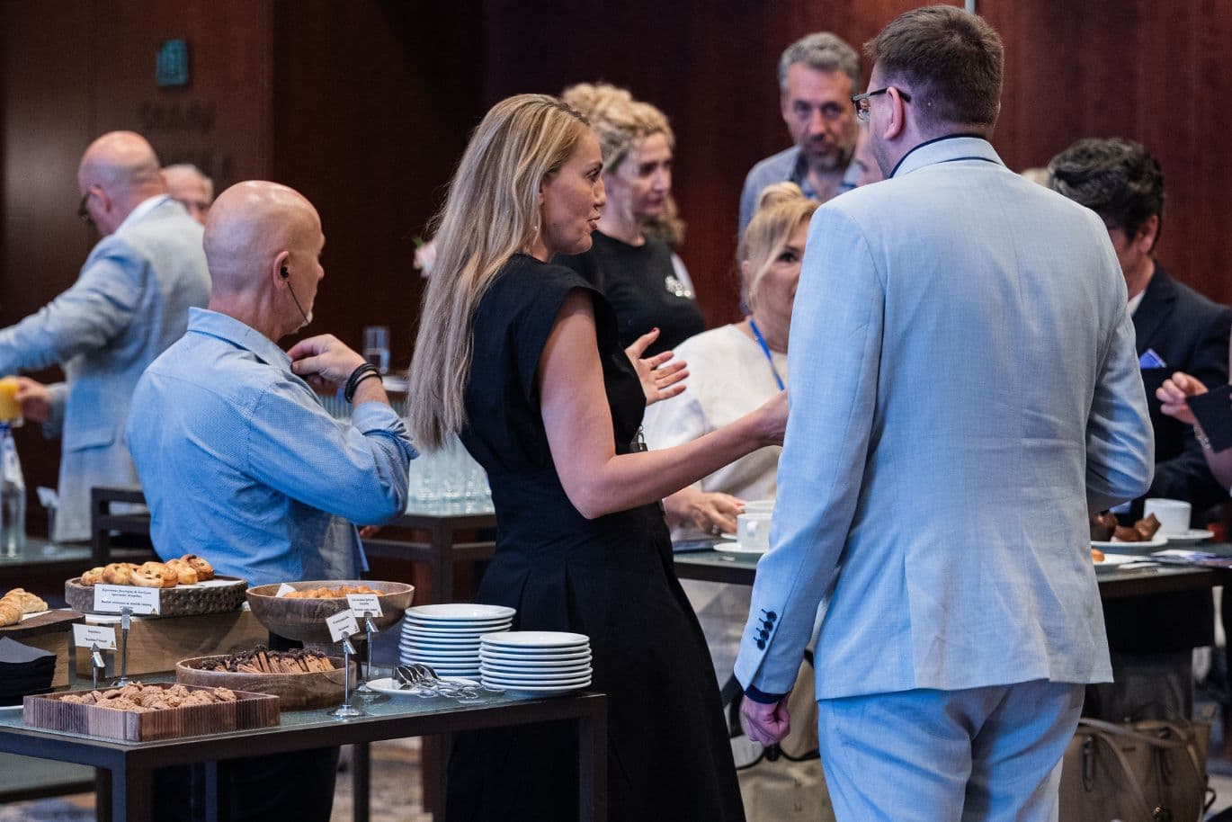 Attendees networking and exchanging ideas during a business event.