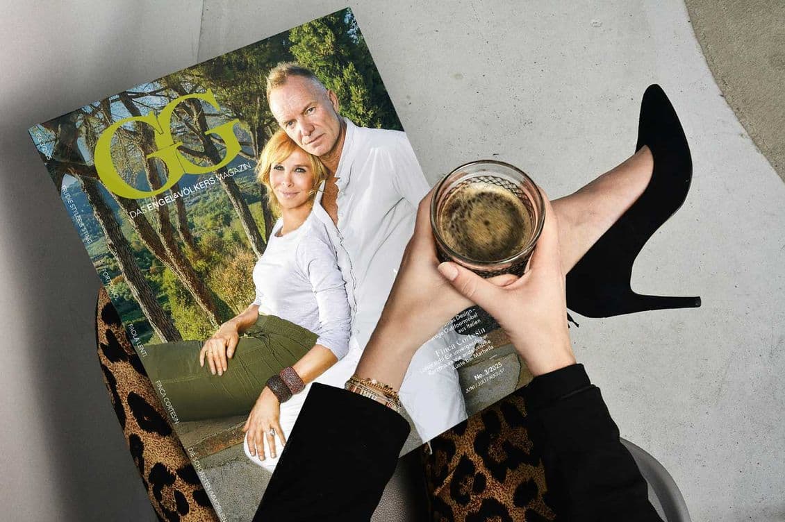Elegáns nő ül egy székben, kezében egy pohár ital, ölében a GG magazin legújabb száma, melynek címlapján Sting és felesége látható.