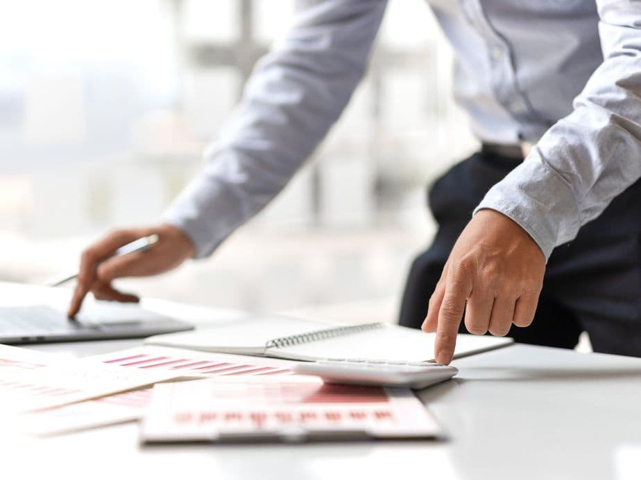 Business meeting with investment documents and property analysis in a professional office setting