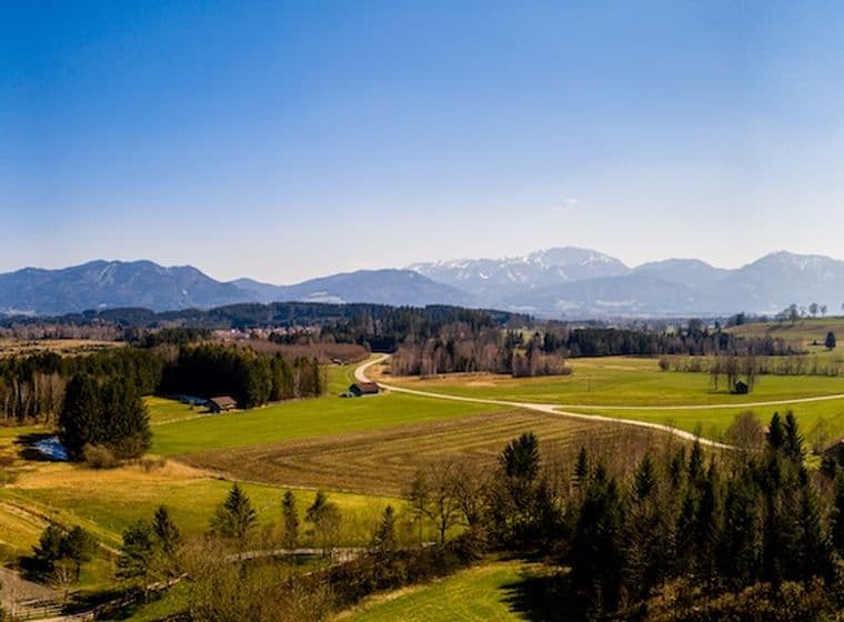 Weitläufiges Luftbild von Penzberg in Bayern mit Alpenpanorama, Wäldern und Wiesen – attraktiver Wohnstandort in malerischer Natur