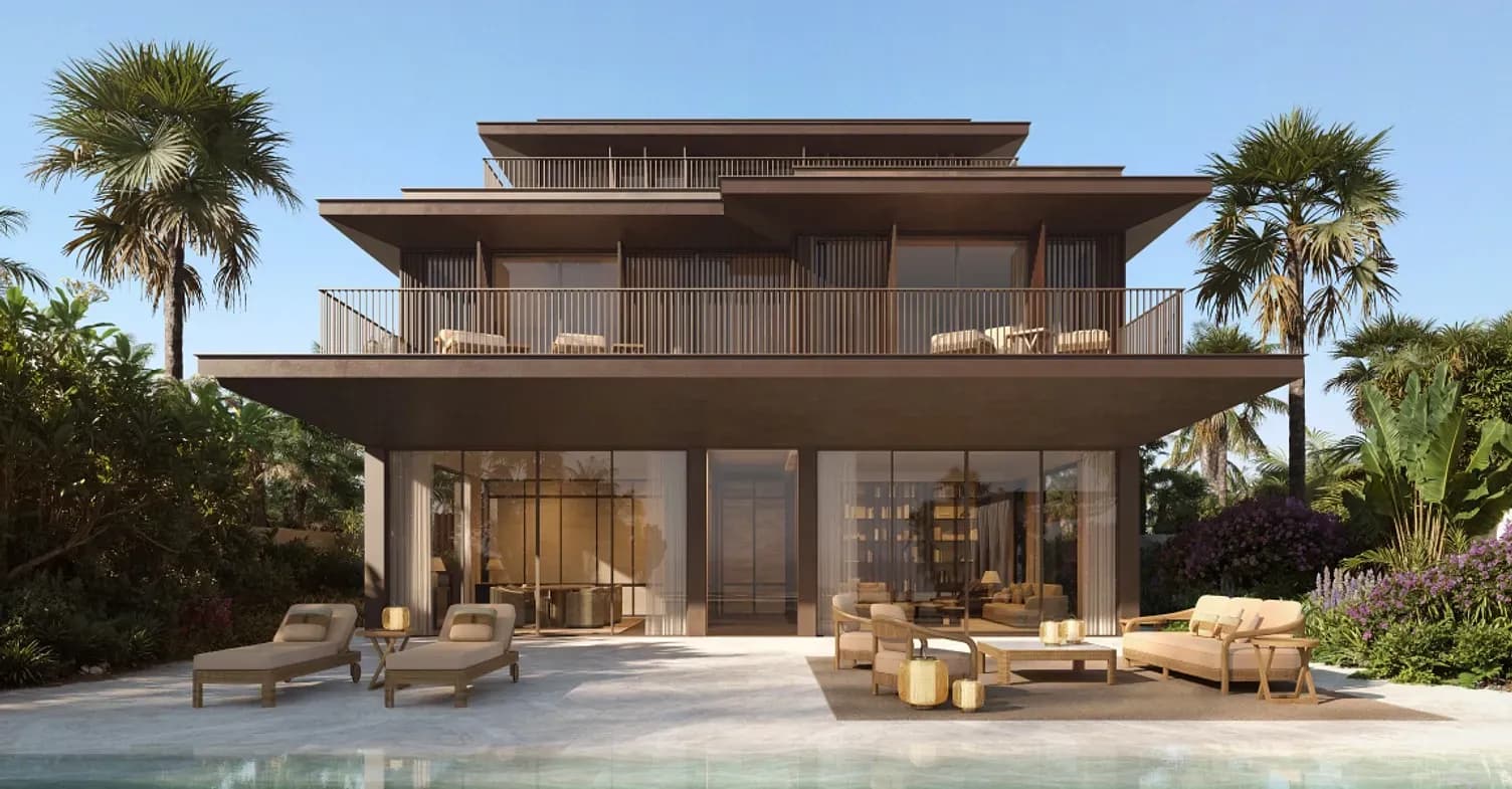 Modern multi-story beach house with large glass windows, surrounded by palm trees, featuring poolside loungers and outdoor seating.