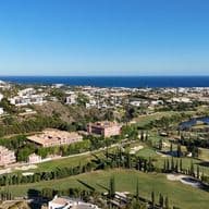 Aerial panorama of Los Flamingos Golf Course in Marbella showing the lake and the sea as well as the 5 star Hotel Anantara Villa Padierna Palace
