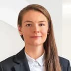 Professional portrait of Barbora Halířová with long brown hair, wearing a black blazer and white shirt.