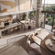 Woman standing on balcony of duplex apartment at Distrikt, overlooking greenery in the Ghaf Woods community.