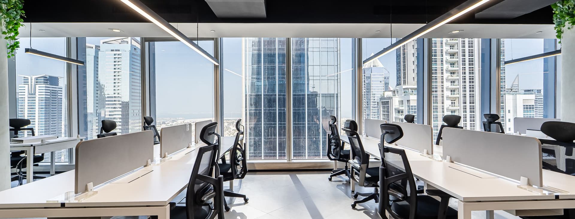 Spacious office floor at Vision Tower with large windows, modern workstations, and abundant natural light