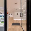 Vetrina dello shop Engel & Völkers di Perugia con facciata in pietra chiara, annunci immobiliari di pregio esposti e porta in vetro aperta con espositore di brochure.