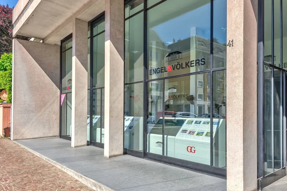Engel & Völkers shop window, with glass panels displaying property listings.