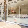 Vetrina dello shop Engel & Völkers di Padova con facciata in pietra chiara, annunci immobiliari di pregio esposti e porta in vetro aperta con espositore di brochure.