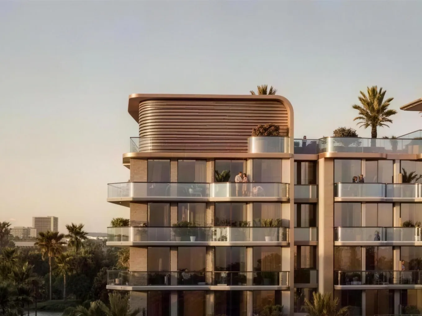 Modern glass apartment building with a rounded top, spacious balconies, and palm trees at sunset.