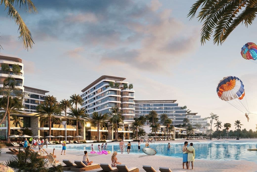 Beach resort with modern buildings, palm trees, people relaxing, parasailing, and a sunset sky. Families and couples enjoy the sandy shore.