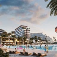 Beach resort with modern buildings, palm trees, people relaxing, parasailing, and a sunset sky. Families and couples enjoy the sandy shore.