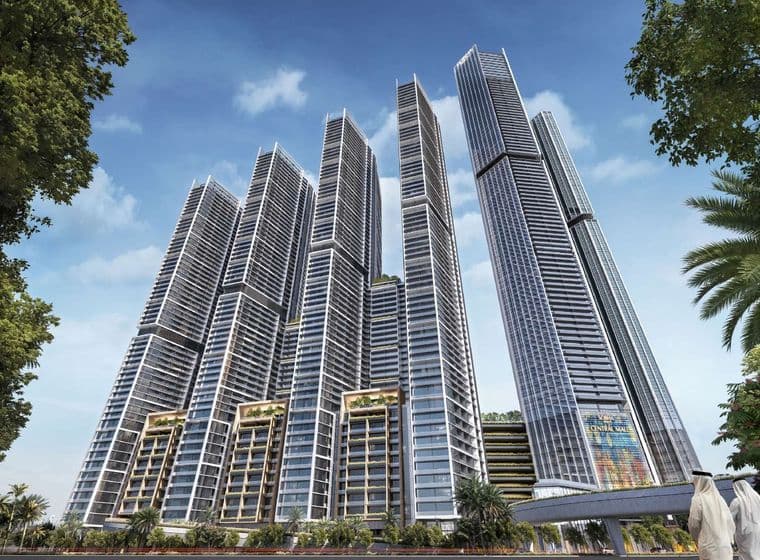 Cluster of modern skyscrapers with glass facades, set against a blue sky, surrounded by palm trees and greenery.