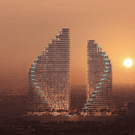 Two sail-shaped skyscrapers at sunset, with glowing lights and a hazy cityscape in the background.